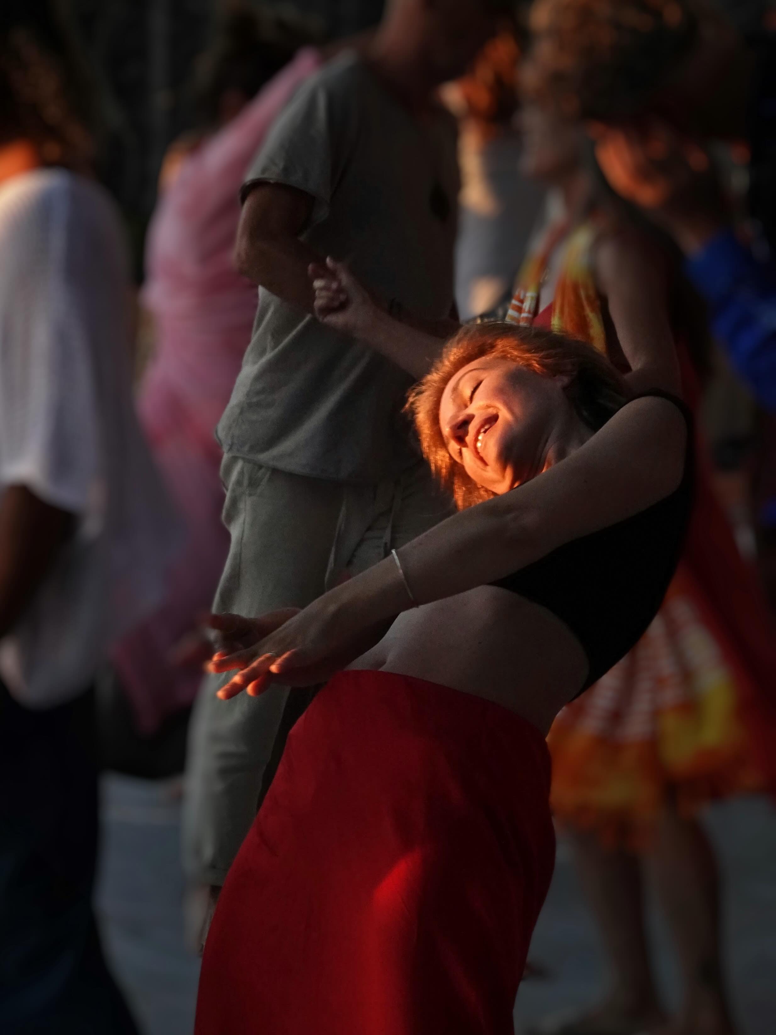 A dancer leans back into the music in warm golden light at SHINE 2026
