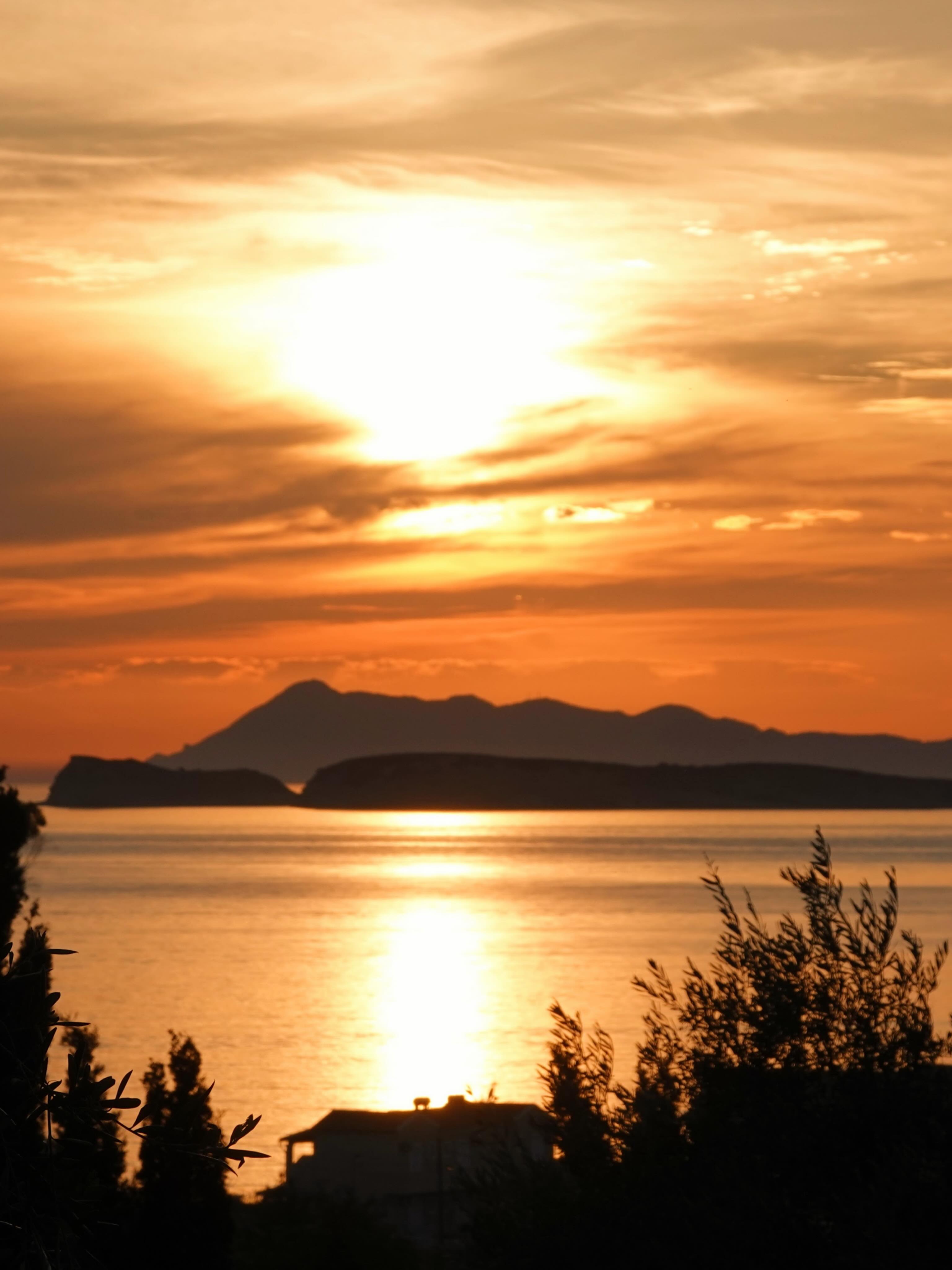 Golden sunlight over the sea and island silhouettes near Corfu